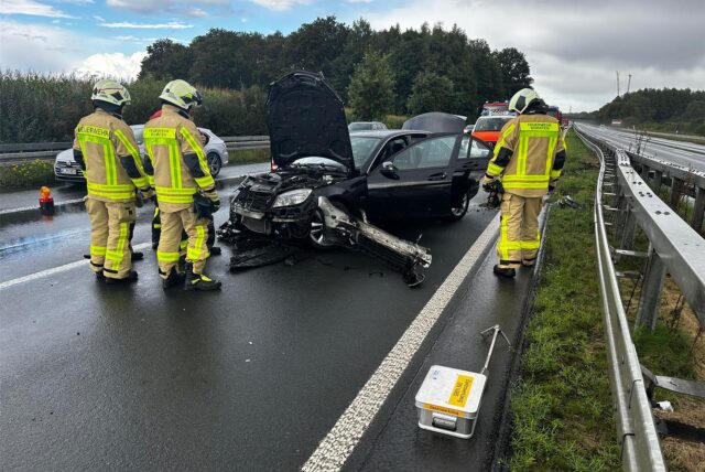 Feuerwehrleute stehen nach einem Unfall vor einem Auto auf der A31 bei Dorsten.