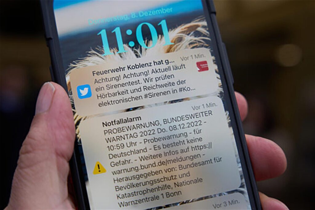 Eine Cell-Broadcast-Botschaft ist am bundesweiten Warntag auf einem Handy Display zu sehen.