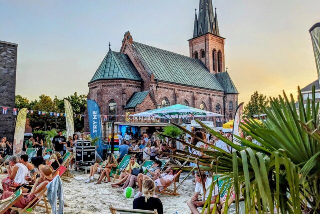 Besucher sitzen bei „Dorsten karibisch“ auf Liegestühlen am Strand in der Altstadt.