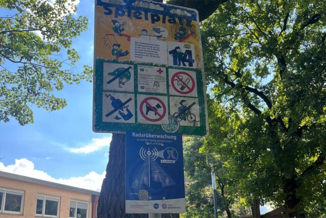 Mit einem Schild weist die Stadt Gelsenkirchen darauf hin, dass ein Spielplatz nahe der Innenstadt mit einem radar- und KI-basiertem Überwachungssystem ausgestattet ist.