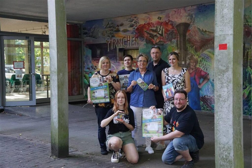 Menschen stehen mit Plakaten vor einer Wand Menschen stehen mit Plakaten vor einer Wand