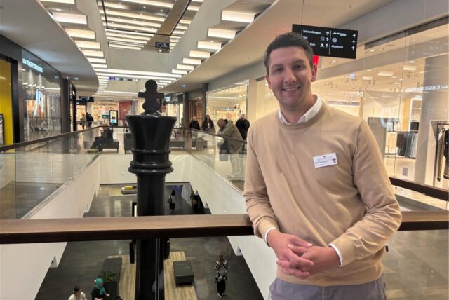 Centermanager Gerrit Beckmann steht in einem Gang des Palais Vest in Recklinghausen. Er lehnt an einer Brüstung.