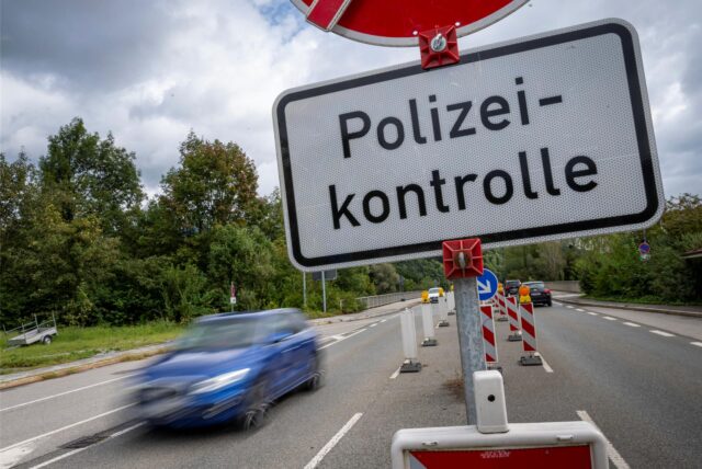 Inmitten einer Straße weist ein Schild auf eine Polizeikontrolle hin. (Symbolbild)