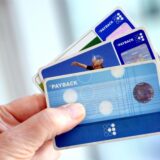 Eine Hand hält drei verschiedene PAYBACK-Karten in die Kamera.