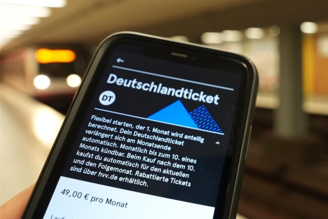Ein Handybildschirm wird gezeigt, auf dem man Informationen zum Abo des Deutschlandtickets lesen kann.