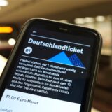 Ein Handybildschirm wird gezeigt, auf dem man Informationen zum Abo des Deutschlandtickets lesen kann.