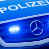 Ein Einsatzfahrzeug der Polizei fährt mit Blaulicht durch die Innenstadt.