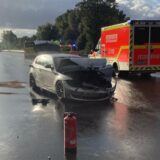 Unfallfahrzeug und Rettungswagen auf der A42 im Gegenlicht.