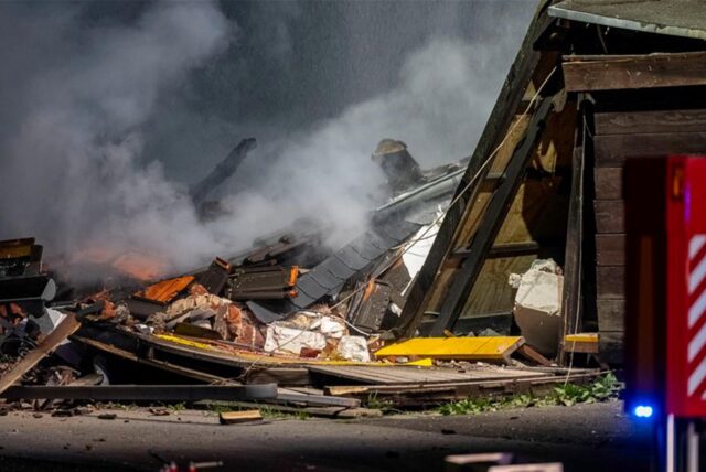 Ein Fahrzeug der Feuerwehr steht vor einem in Trümmern liegenden Haus. In einem Einfamilienhaus im nordrhein-westfälischen Alpen ist es zu einer Explosion in einem Wohnhaus gekommen.
