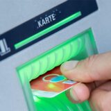 Eine EC-Karte wird in den Schlitz eines Geldautomaten gesteckt.