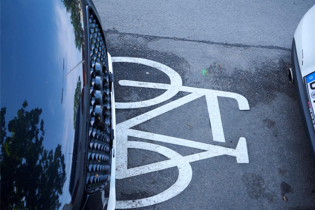 Ein Auto fährt auf einem Radweg. Ein Auto fährt auf einem Radweg.