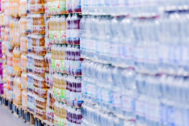 Paletten mit Getränkeflaschen stehen in einem Supermarkt.