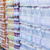 Paletten mit Getränkeflaschen stehen in einem Supermarkt.