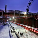 Zahlreiche Besucher fahren auf der Eisbahn Kokerei Zollverein in Essen mit ihren Schlittschuhen