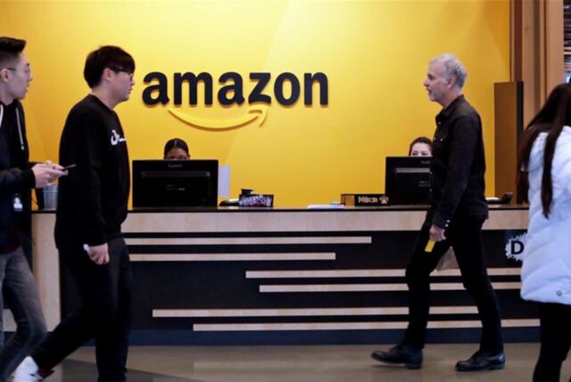 Mitarbeiter gehen durch eine Lobby der Amazon-Zentrale. (