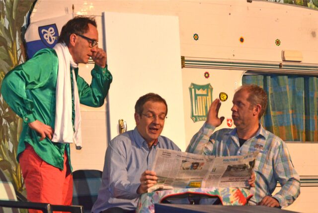 Theaterspieler vor einem Wohnwagen