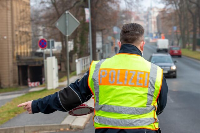 Ein Polizist winkt einen Autofahrer auf den Seitenstreifen.