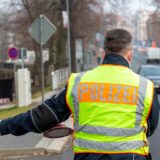 Ein Polizist winkt einen Autofahrer auf den Seitenstreifen.