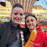 Zwei Besucher der Castroper Herbstkirmes stehen vor einem Karussell auf dem Marktplatz.