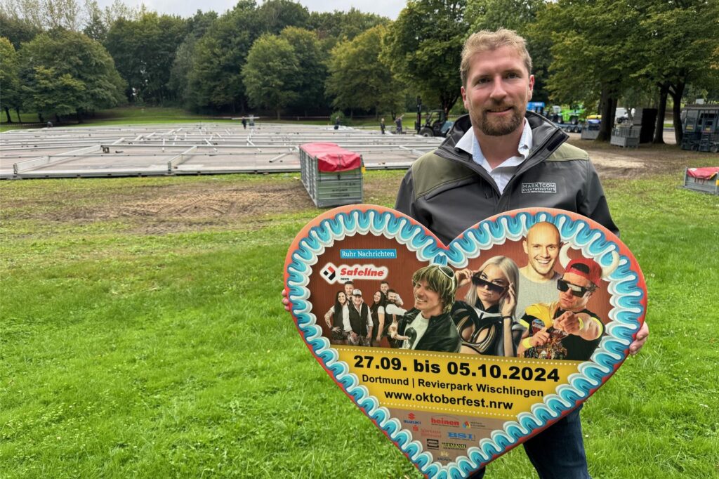 Organisator Nils Linke zeigt ein Plakat für das Dortmunder Oktoberfest 2024 in Form eines Lebkuchenherzes. Organisator Nils Linke zeigt ein Plakat für das Dortmunder Oktoberfest 2024 in Form eines Lebkuchenherzes.