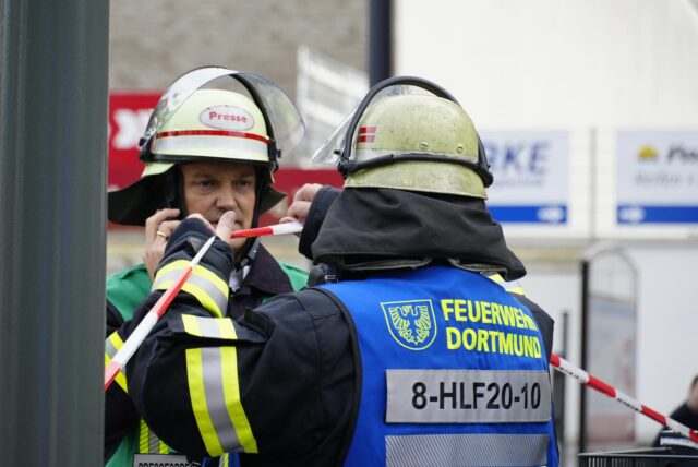 Zwei Feuerwehrleute sprechen in Dortmund miteinander.