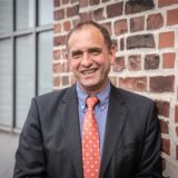 Sascha Mader, Vorsitzender CDU-Kreisverbands Dortmund, lehnt an der Außenmauer eines Gebäudes.