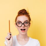 Neugierige Frau mit Brille und Bleistift