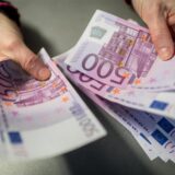 Zwei Hände halten 500 Euro Scheine. Die Person zählt sie durch.