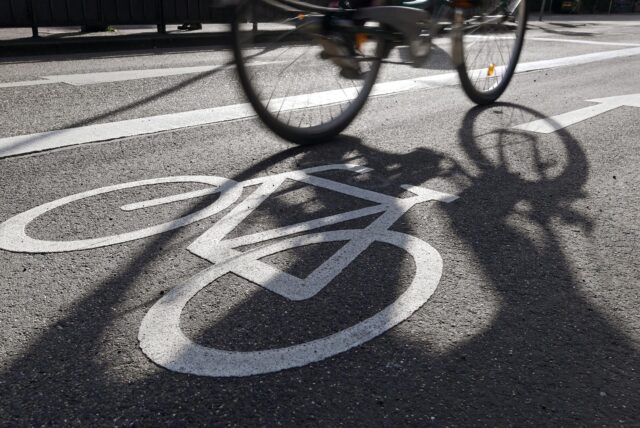 Ein Fahrrad fährt über Asphalt mit einer Fahrradweg-Markierung