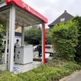 Am Tag nach der Geldautomaten-Sprengung in Dortmund-Oespel sicherten Handwerker den zerstörten Container. Ein Teil des Geldautomaten blieb heil.