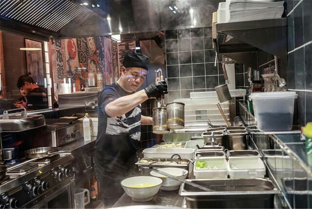 Ein Mann kocht in einer offenen Küche eines Restaurants