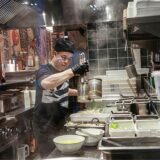 Ein Mann kocht in einer offenen Küche eines Restaurants