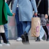 Menschen mit vollen Einkaufstaschen gehen am verkaufsoffene Sonntag shoppen und bummeln.