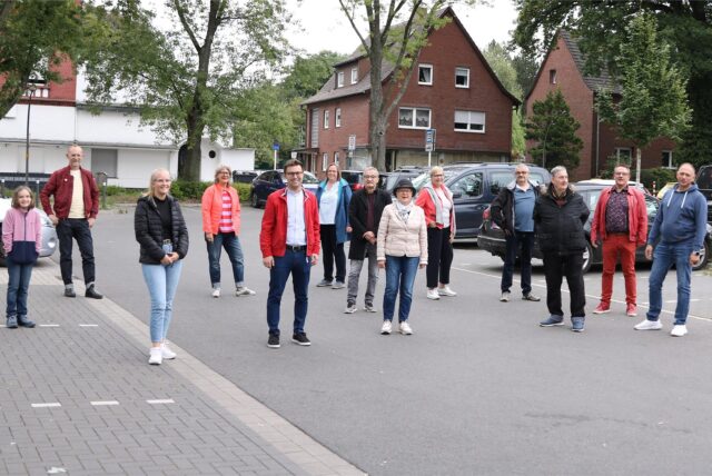 Mitglieder der SPD Sinsen-Lenkerbeck stehen auf dem Parkplatz am Bahnhof Sinsen. Sie fordern hier die Einrichtung von Ladesäulen für Elektroautos.