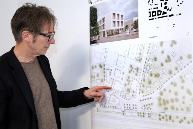 Architekt zeigt auf einen Plan.