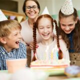 Auf einem Kindergeburtstag freuen sich die Gäste über den Geburtstagskuchen.