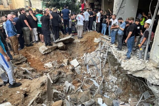 Menschen versammeln sich am Ort eines israelischen Raketeneinschlags in den südlichen Vororten von Beirut.