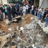 Menschen versammeln sich am Ort eines israelischen Raketeneinschlags in den südlichen Vororten von Beirut.