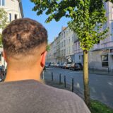 Ein Mann steht mit dem Rücken zur Kamera an einer Straße in der Dortmunder Nordstadt.