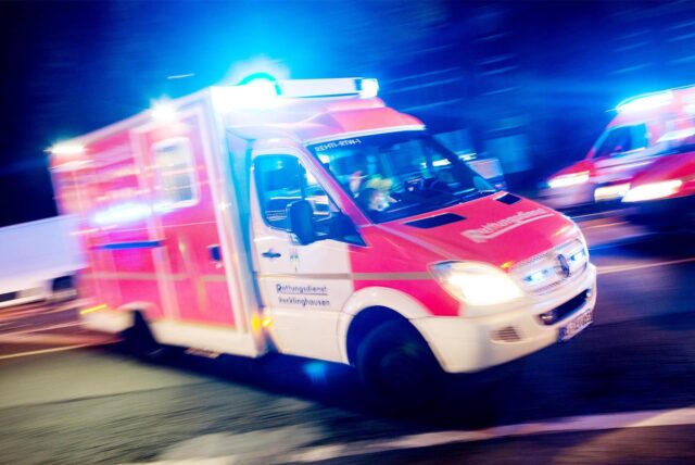 Ein Rettungswagen fährt mit Blaulicht durch eine Straße.