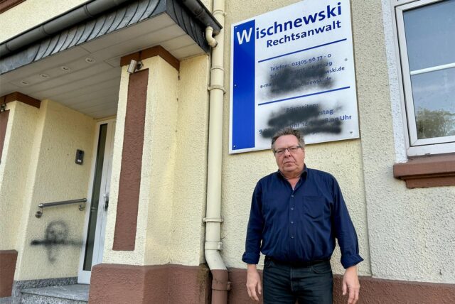 Jürgen Wischnewski vor seiner Anwaltskanzlei an der Dortmunder Straße. Eigentlich stehen vorne auf dem Schild Öffnungszeiten und Erreichbarkeiten. Diese sollten wohl unkenntlich gemacht werden.
