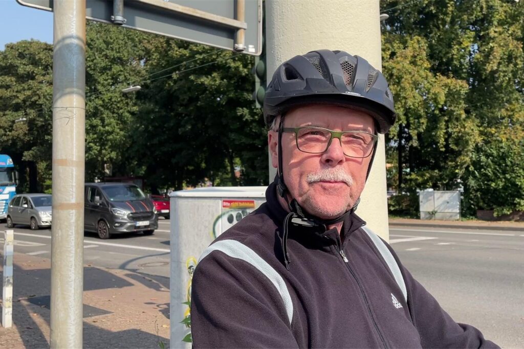 Ein Fahrradfahrer mit Helm steht an einer Kreuzung in Datteln und wird befragt. Ein Fahrradfahrer mit Helm steht an einer Kreuzung in Datteln und wird befragt.