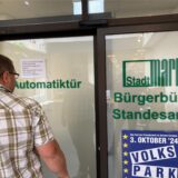 Ein Mann steht vor einer Tür zum Bürgerbüro in Marl.