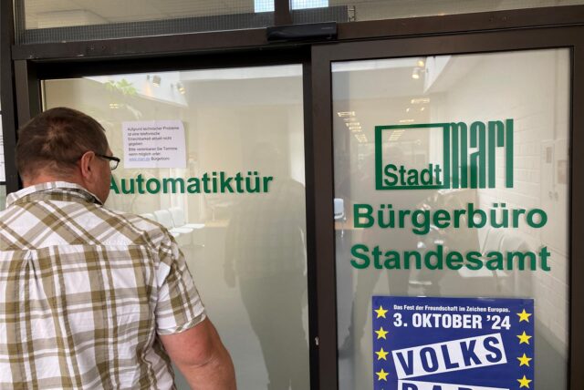 Ein Mann steht vor einer Tür zum Bürgerbüro in Marl.