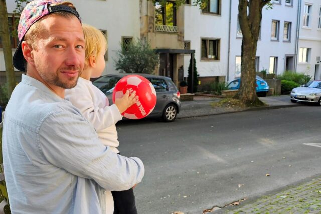 Ein Vater hält seinen Sohn auf dem Arm.