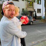Ein Vater hält seinen Sohn auf dem Arm.