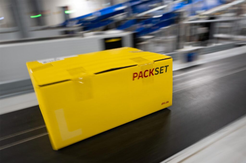 Ein Paket rollt über das Laufband eines DHL-Paketzentrums.