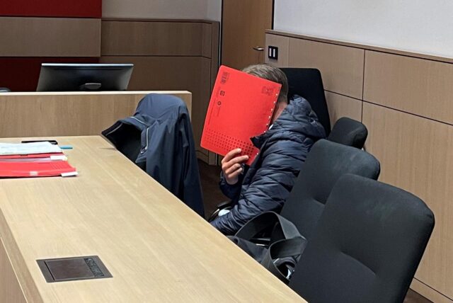 Der geständige „falsche Polizist“ versteckt kurz vor dem Prozessauftakt vor der 7. Strafkammer am Bochumer Landgericht sein Gesicht hinter einem roten Aktendeckel.