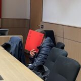 Der geständige „falsche Polizist“ versteckt kurz vor dem Prozessauftakt vor der 7. Strafkammer am Bochumer Landgericht sein Gesicht hinter einem roten Aktendeckel.
