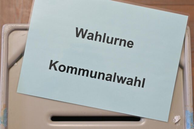Ein Zettel mit der Aufschrift «Wahlurne Kommunalwahl» liegt auf einer Wahlurne in einem Wahllokal.